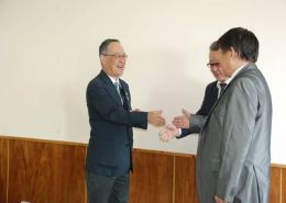 握手を交わす松川節教授(左)