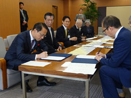 立会人の山野金沢市長、木越学長による署名